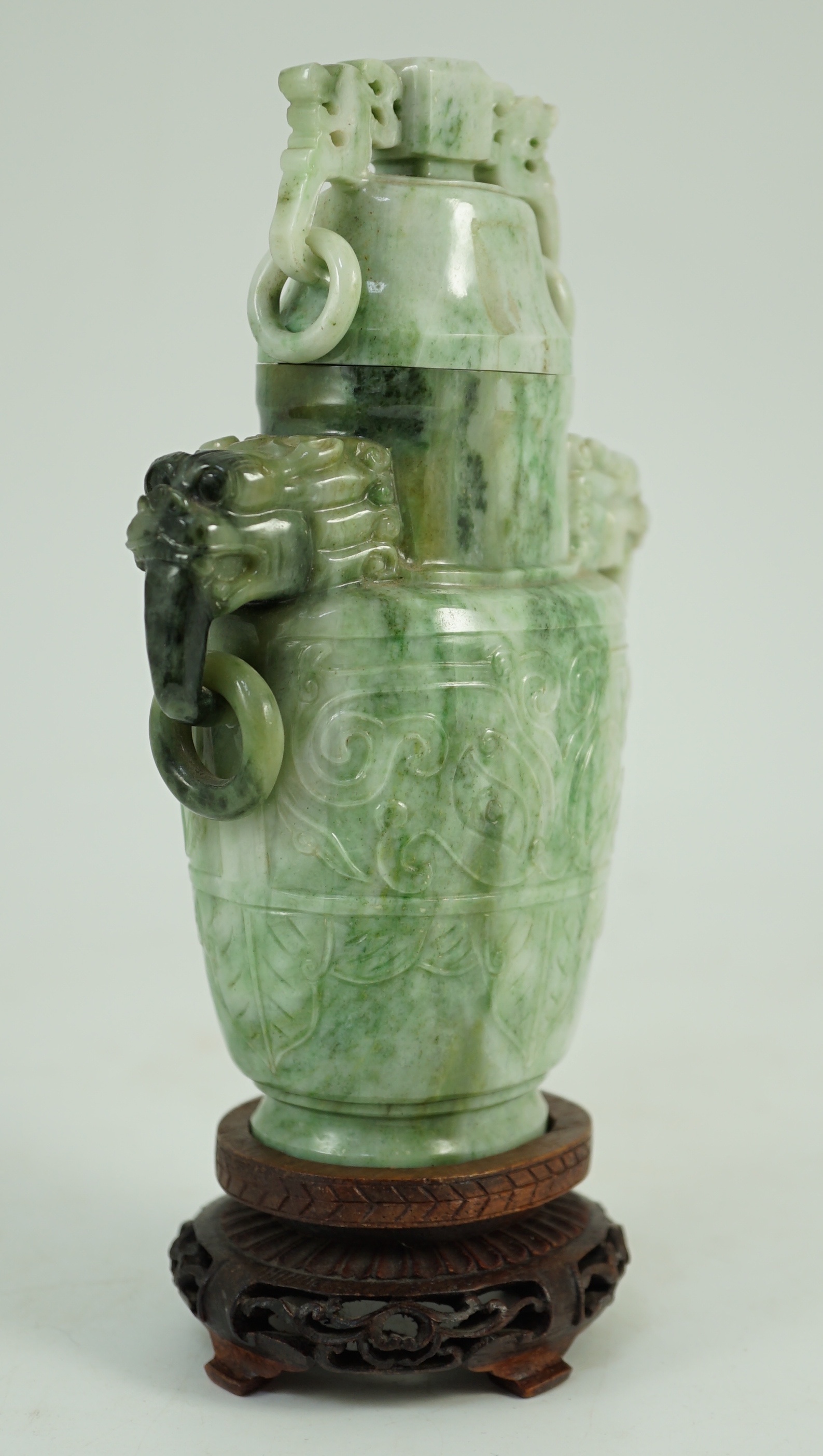 A Chinese archaistic jadeite two-handled vase and cover, first half 20th century, 16 cm high, excluding wood stand